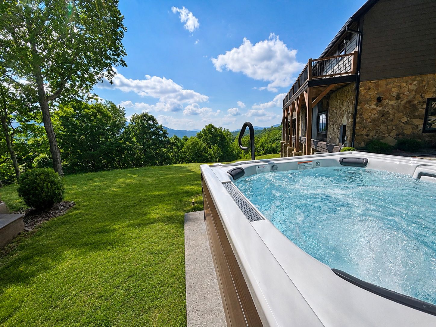 Swim spa on a manicured lawn beside a stone mountain home with Blue Ridge views, High Country NC